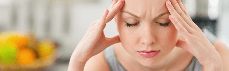 Kvinde med hovedpine eller migræne